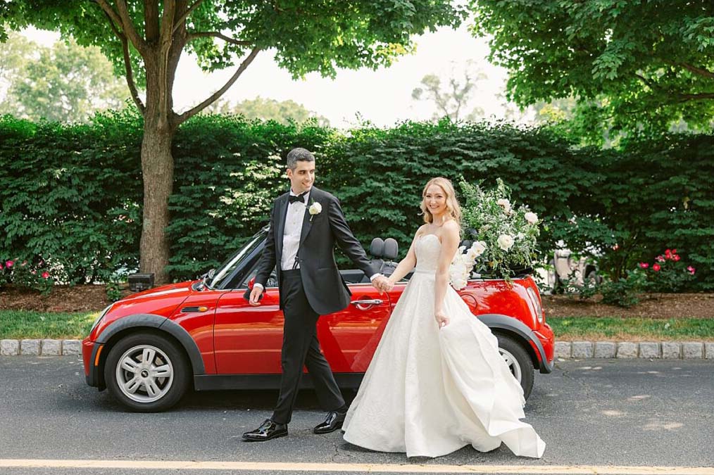 lauren kearns brooklake wedding reception outdoors bride and groom by red sports car