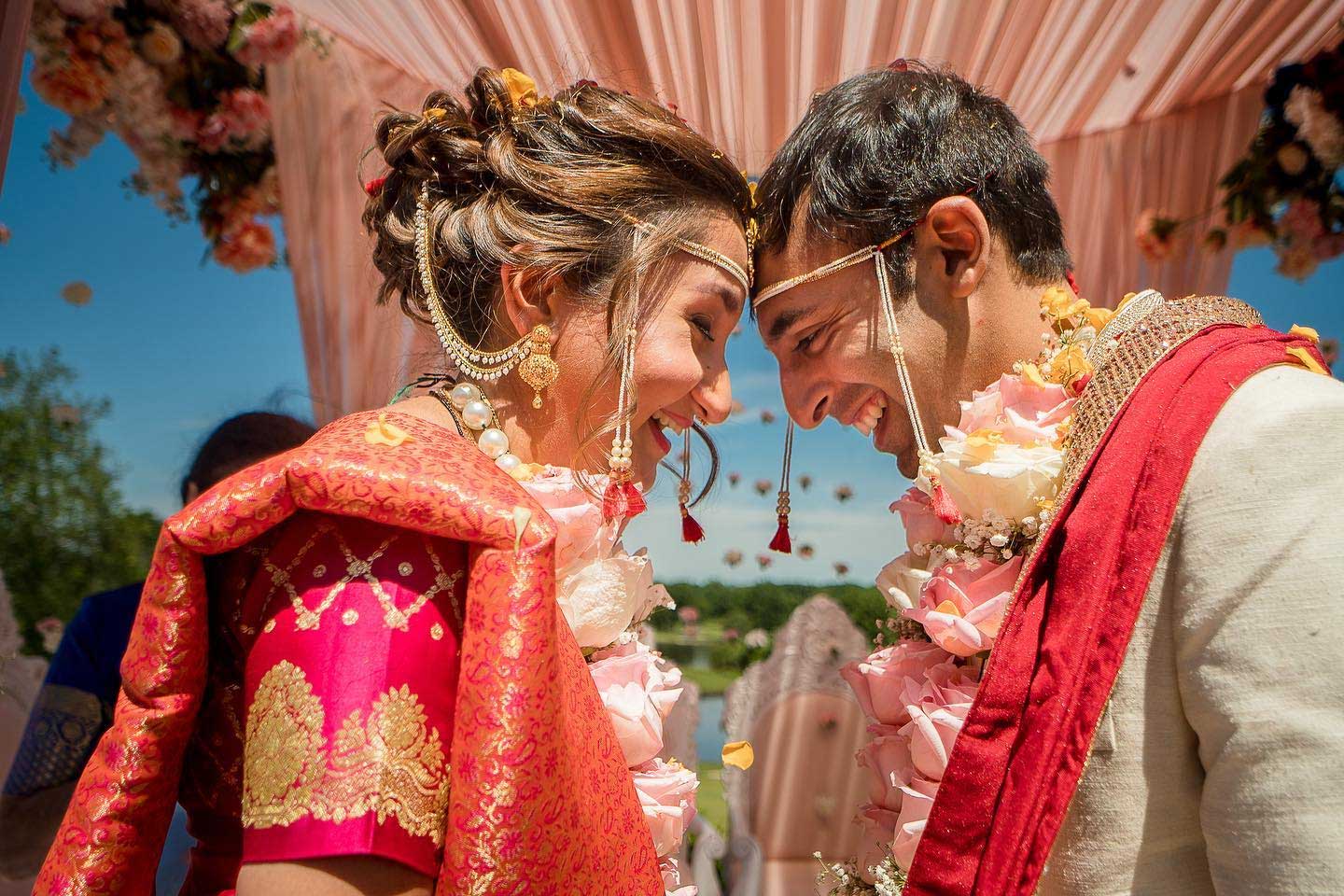 brooklake-couple-with-heads-together A bride and groom in traditional attire touch foreheads and smile during a wedding ceremony under a decorated canopy at one of the NJ Teen Events.