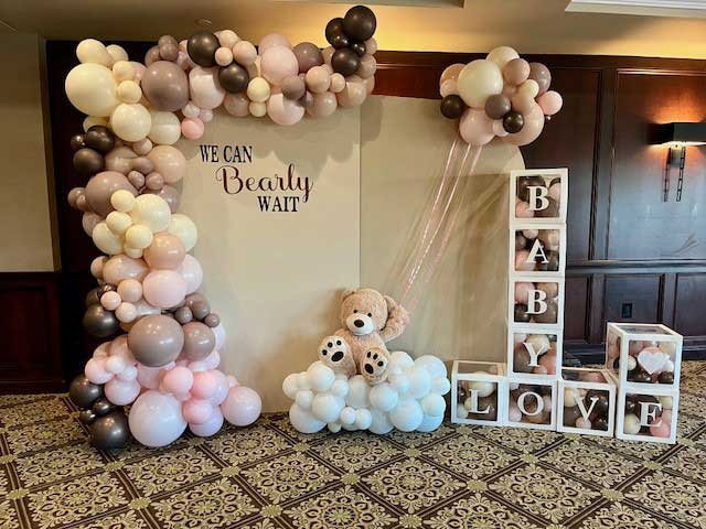 waterford-room-baby-shower-bears-balloons Balloon arch with pastel and brown tones, a teddy bear, and stacked boxes spelling "BABY LOVE" set up for a baby shower with the sign "We Can Bearly Wait"—perfect for NJ Teen Events and special celebrations.
